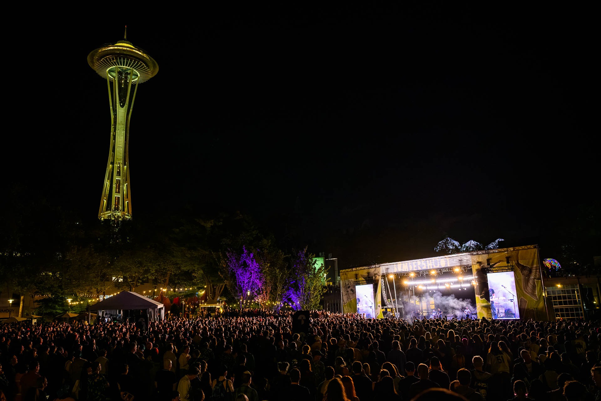 A view of the main stage a Bumbershoot at night with the Space Needle in the background.